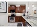 Well-lit kitchen featuring stainless steel appliances and dark wood cabinets at 21232 N 262Nd Dr, Buckeye, AZ 85396