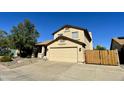 Exterior shot of tan home with a two-car garage and a wooden gate at 24809 N 41 Ave, Glendale, AZ 85310