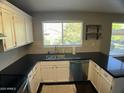 Well-lit kitchen with white cabinets, dark countertops and stainless steel appliances at 24809 N 41 Ave, Glendale, AZ 85310