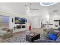 Cozy living room featuring modern ceiling fan, a large entertainment center, and stylish decor at 4718 E Mossman Rd, Phoenix, AZ 85050