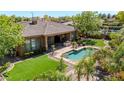 Aerial view of backyard featuring an outdoor kitchen, pool, patio, and lush lawn at 5206 S Fairchild Ln, Chandler, AZ 85249