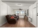 Living room with brown leather reclining sofa, ceiling fan and wood flooring at 5735 E Mcdowell E Rd # 213, Mesa, AZ 85215