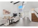 Bright living room features a fireplace, high ceilings, gray tile, and staircase to the second level at 7209 E Mcdonald Dr # 51, Scottsdale, AZ 85250