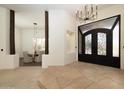 Grand foyer featuring decorative iron doors, designer lighting, and flagstone flooring at 8233 E Foothill Cir, Scottsdale, AZ 85255