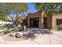 Inviting front entrance featuring desert landscaping, a charming courtyard, and an artistic front door at 8233 E Foothill Cir, Scottsdale, AZ 85255