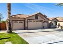 Spacious three-car garage and a well-maintained lawn, enhancing the property's exterior appeal at 859 E Teakwood Dr, Chandler, AZ 85249