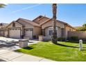 Lovely home featuring a three-car garage, a tidy lawn, and mature landscaping for added beauty at 859 E Teakwood Dr, Chandler, AZ 85249