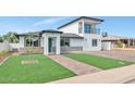 Inviting home exterior with a green lawn, brick driveway, and a stylish two-story design at 92 N Palm St, Gilbert, AZ 85234