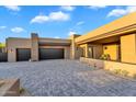 Beautiful modern home exterior features a large driveway and attached garages, complemented by desert landscaping at 10354 E Celestial Dr, Scottsdale, AZ 85262