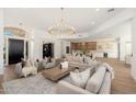 Spacious living area with views into the kitchen, bar, and dining area, decorated with comfortable seating and neutral tones at 11267 E Beck Ln, Scottsdale, AZ 85255