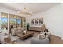 Sophisticated living room with stylish decor, neutral tones, and a large sliding glass door leading to an outdoor patio at 11267 E Beck Ln, Scottsdale, AZ 85255