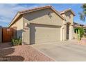 Well-maintained single-story home featuring a two-car garage, desert landscaping, and a terracotta tile roof at 16936 W Stevenage St, Surprise, AZ 85374