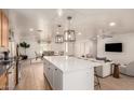 Open concept kitchen with a large island, pendant lights, and a view of the dining and living areas at 1838 E Crocus Dr, Phoenix, AZ 85022