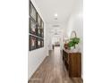 Inviting hallway with wood-look tile flooring, a picture gallery and stylish decor at 19181 W Jackson St, Buckeye, AZ 85326