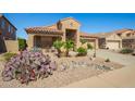 Charming home features desert landscaping with cacti, a tile roof, and a cozy front porch at 22499 N Dietz Dr, Maricopa, AZ 85138
