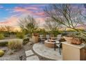 Desert home backyard featuring a stone firepit with chairs, complemented by desert landscaping and desert mountain views at 37170 N Greythorn Cir, Carefree, AZ 85377