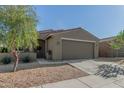 Close up front exterior view of single story home with a well maintained yard and neutral color paint at 40467 W Jenna Ln, Maricopa, AZ 85138