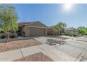 A single story home with a two car garage, desert landscaping, and neutral exterior paint at 40467 W Jenna Ln, Maricopa, AZ 85138