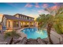Inviting backyard pool with lush tropical landscaping and a charming waterfall feature at 4455 E Palmdale Ln, Gilbert, AZ 85298