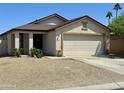 Beige single-story home with desert landscaping, featuring a two-car garage and a concrete driveway at 592 E 9Th Ave, Apache Junction, AZ 85119
