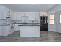 Modern kitchen featuring white cabinets, black countertops, and stainless steel appliances at 6025 W Marconi Ave, Glendale, AZ 85306
