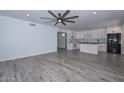 Open-concept living room and kitchen with gray floors, white cabinets, and modern appliances at 6025 W Marconi Ave, Glendale, AZ 85306