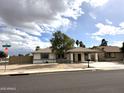 Street view of a well-maintained single-story home with covered parking at 6201 W Acoma Dr, Glendale, AZ 85306