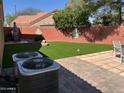Lush backyard with well-maintained artificial turf, patio area, and mature landscaping, offering a private outdoor space at 657 N Marble St, Gilbert, AZ 85234