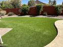 Expansive backyard featuring well-maintained artificial turf and desert landscaping, perfect for outdoor activities and entertaining at 657 N Marble St, Gilbert, AZ 85234