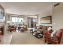 Bright living room featuring neutral tones, a plush sofa, cozy chairs, and seamless access to the outdoor balcony at 7700 E Gainey Ranch Rd # 222, Scottsdale, AZ 85258