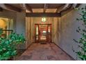 View of the front entrance with a custom door and well-lit entrance. Plants add to the appeal at 8003 E Sands Dr, Scottsdale, AZ 85255
