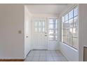 Bright foyer featuring tile flooring, decorative front door, and a large window at 10647 N 63Rd Dr, Glendale, AZ 85304