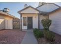 Close-up of front entrance featuring a white door, security screen and quaint front yard at 10647 N 63Rd Dr, Glendale, AZ 85304