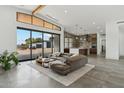 Open concept living room and kitchen with brick accent wall and large glass doors at 12416 N 65Th Pl, Scottsdale, AZ 85254