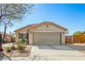 Tan single story home featuring desert landscaping with a two-car garage and concrete driveway at 1268 S 238Th Ln, Buckeye, AZ 85326