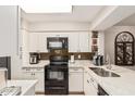 Well-lit kitchen with white cabinets and modern black appliances at 1718 S Longmore St # 116, Mesa, AZ 85202