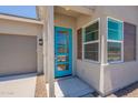 Stylish home featuring a bright blue front door with decorative glass panels, and a modern window at 17966 W Long Lake Rd, Goodyear, AZ 85338