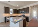Well-equipped kitchen with stainless steel appliances, dark cabinetry, and a center island with granite countertops at 17966 W Long Lake Rd, Goodyear, AZ 85338