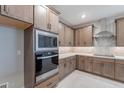 This kitchen features built-in stainless appliances, neutral backsplash tile, and stained cabinets at 2121 W Sonoran Desert Dr # 95, Phoenix, AZ 85085