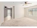 Bright bedroom featuring neutral carpet, ceiling fan and large window at 2187 W Kristina Ave, Queen Creek, AZ 85144