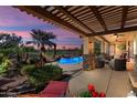 Backyard patio with golf course view, landscaping, and a pool with lighting for nighttime enjoyment at 23024 N De La Guerra Ct, Sun City West, AZ 85375