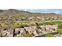 Scenic aerial view of a neighborhood, showcasing desert landscaping, golf course and mountain views at 2534 W Muirfield Dr, Anthem, AZ 85086