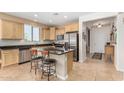 Well-equipped kitchen with granite countertops, stainless steel appliances, central island, and tile flooring at 26237 W Vista North Dr, Buckeye, AZ 85396