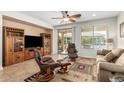 Inviting living room with neutral tones, tile floors, ceiling fan, and sliding doors to backyard at 26237 W Vista North Dr, Buckeye, AZ 85396