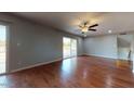 Open living room features hardwood floors, sliding glass doors, modern ceiling fan, and neutral walls at 4216 W Solano Dr, Phoenix, AZ 85019