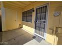 Private patio area with security door and yellow siding, perfect for relaxation and outdoor living at 4816 E Corral Rd # 2, Phoenix, AZ 85044