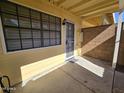 Covered patio features a concrete floor, security door, and tan siding, perfect for outdoor relaxation at 4816 E Corral Rd # 2, Phoenix, AZ 85044