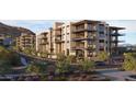 Beautiful exterior view of the modern apartment buildings with lush landscaping and mountain backdrop at 4849 N Camelback Ridge Rd # A106, Scottsdale, AZ 85251