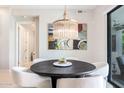 Stylish dining area with a round table, elegant chandelier, and modern art at 5250 E Deer Valley Dr # 146, Phoenix, AZ 85054