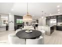 Open-concept dining area with modern light fixture, connecting the kitchen and living spaces at 5250 E Deer Valley Dr # 146, Phoenix, AZ 85054